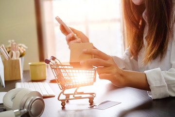 Boxes in a trolley with Woman hands, Shopping online concept.