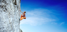 Young Slim Woman Rock Climber Climbing On The Cliff