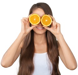 Poster - Portrait of young woman holding halved oranges at her eyes