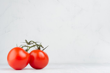 Wall Mural - Pulpy red tomatoes on branch in light soft white modern kitchen interior with copy space.