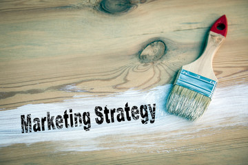 Wall Mural - Marketing Strategy Business concept. paintbrush with white colour on a wooden background
