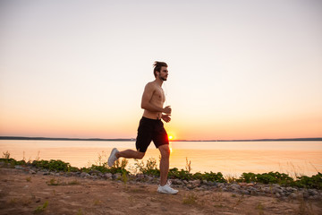 Athletic young man running in the nature. Healthy lifestyle