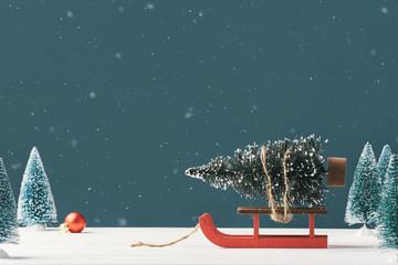 Wall Mural - Christmas card with place for your text. A bright Christmas tree toy in the form of a fir tree on a Santa Claus sleigh on a dark background with toy Christmas trees in the background. Snowing