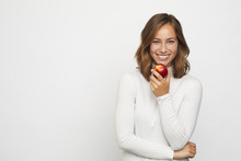 Young Woman With Red Peach Looks In Camera