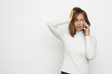 portrait of a young woman on phone having a frustrated conversation and looks right