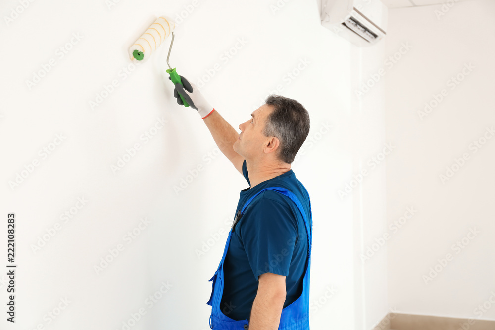 Male painter in uniform working indoors