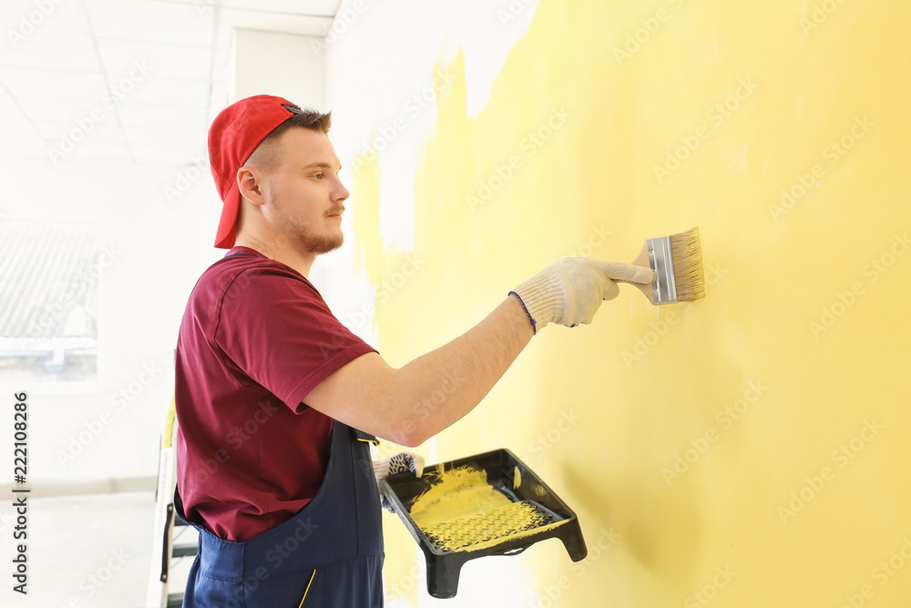 Male painter in uniform working indoors