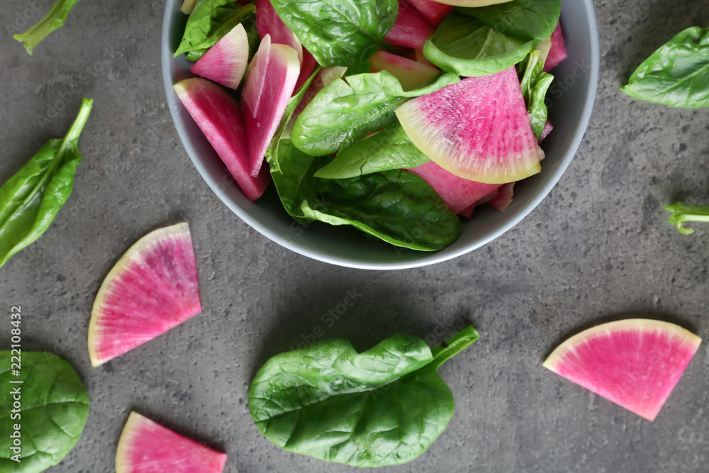 Flat lay composition with fresh sliced radish and leaves on gray background
