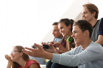 Teenagers playing video games at home