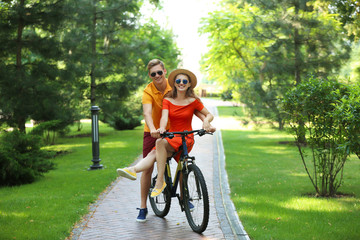 Wall Mural - Young couple riding bicycle in park