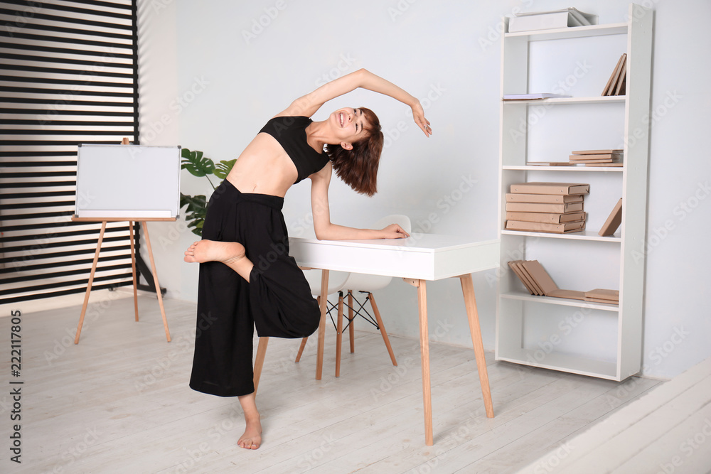 Sporty woman practicing yoga at home