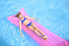 Cute Little Girl Resting On Inflatable Mattress In Swimming Pool