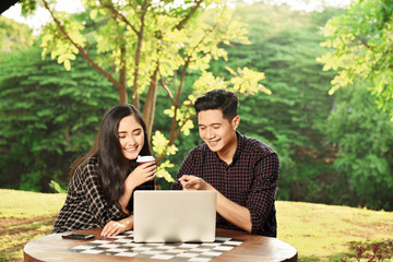 Wall Mural - Happy asian couple with laptop