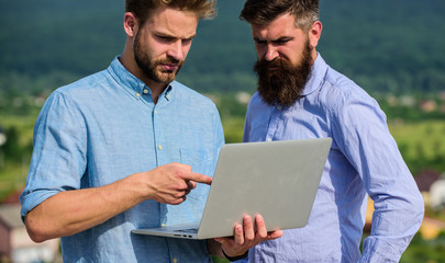 Wall Mural - Business partners in formal wear with laptop or notebook taking advantages of mobile internet working outdoor. Colleagues with laptop work outdoor sunny day nature background. Mobile internet concept