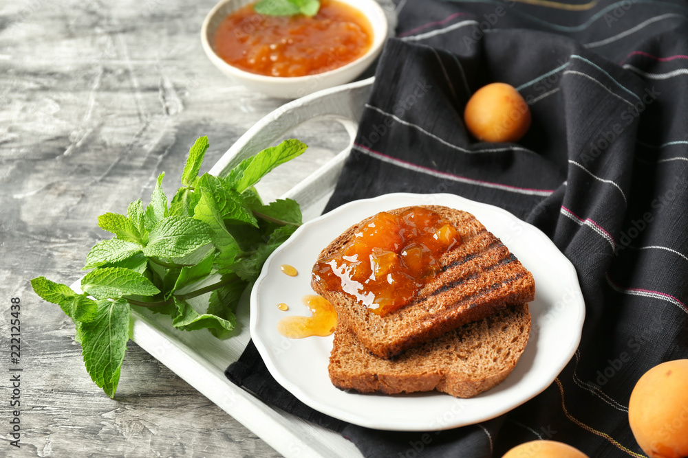Toasted bread with delicious apricot jam on plate