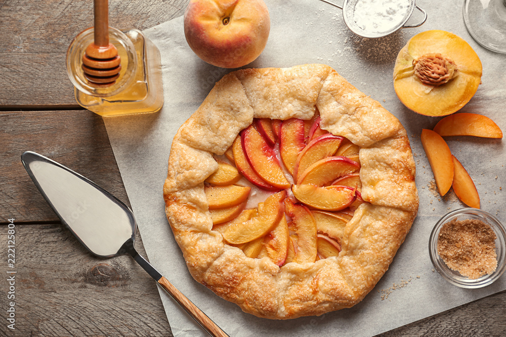 Parchment with delicious peach galette on table