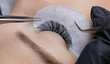 Eyelash extension procedure. Woman master making long lash