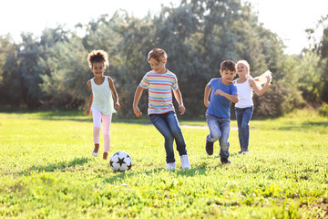 Sticker - Cute little children playing football outdoors