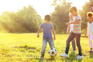 Sticker - Cute little children playing football outdoors