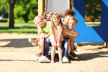 Sticker - Cute little children having fun on playground outdoors