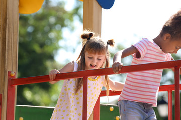 Sticker - Cute little children having fun on playground outdoors