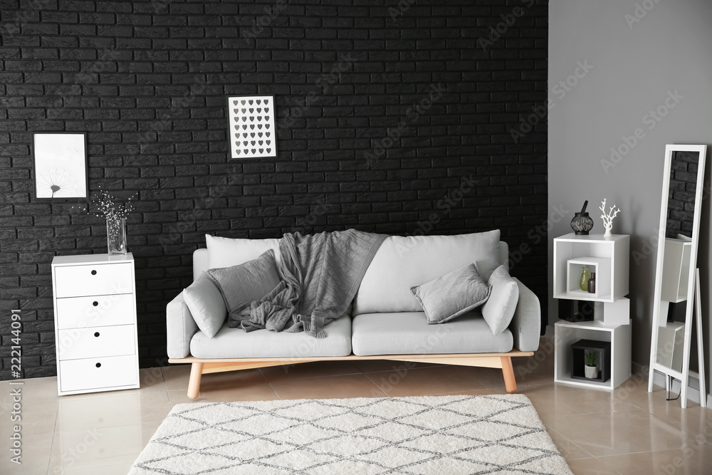 Modern room interior with big mirror and stylish sofa near dark wall