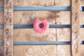 Wall Mural - pink donut on wooden background