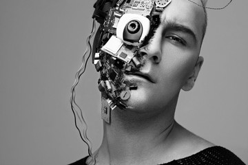 Monochrome studio photo of man cyborg, half face computer elements and with professional make-up, white Iroquois on head. Future technology concept