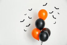 Color Balloons With Paper Bats For Halloween Party On Light Background