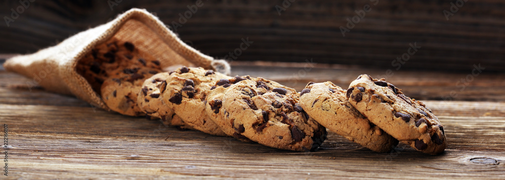 Chocolate cookies on wooden table. Chocolate chip cookies shot. - obrazy, fototapety, plakaty 
