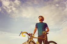 Close Up Of A Cyclist Male Standing With A Road Bike At Sunset, Sportsman In Race Concept.