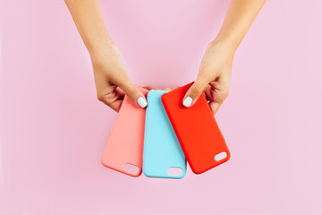 hands holding colorful smartphone cases