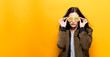 Fashionable woman with attitude in bomber jacket on a golden yellow background