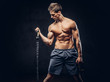 © Fxquadro - Handsome shirtless man with stylish hair and muscular ectomorph doing the exercises with an expander.
