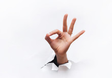 Hand Ok Sign. The Hand Came Out Into The Hole And Shows Symbol Of Fine. Copy Space.