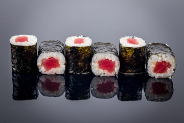 tuna roll on black background with reflection