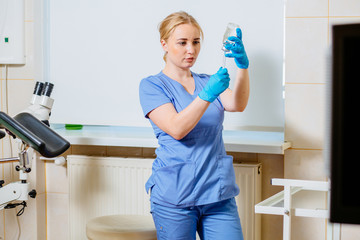 female nurse or doctor's assistant preparing equipm`nt for appointment in medical gynecological clin