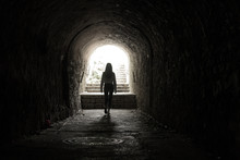 Girl Walking Throug Dark Tunnel Into Light