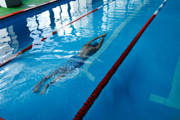 Sticker - Photo on top of athlete man in blue cap swimming on path in pool under water