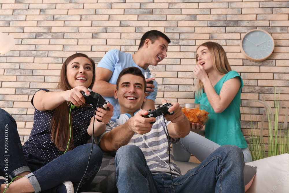 Young people playing video games at home