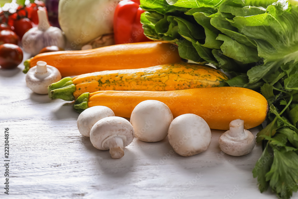 Mushrooms and ripe vegetables on light wooden table