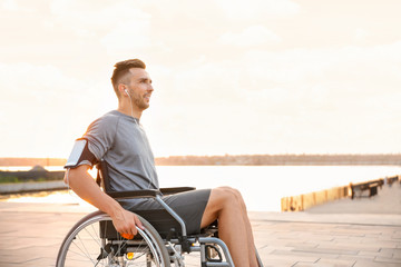 Poster - Young man in wheelchair listening to music outdoors