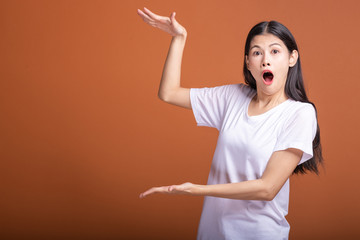 Wall Mural - Surprise woman over orange background.