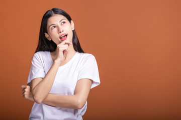 Wall Mural - Thinking woman over orange background.