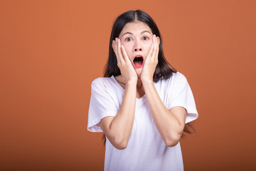 Wall Mural - Surprise woman over orange background.