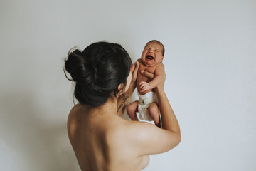 Wall Mural - naked mother holding her infant baby