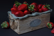 Erdbeeren Bio frisch in einem Holzkisten auf Schwarzem Hintergrund