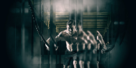 Wall Mural - Man working out with battle ropes. Mirror effect