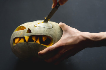 making a pumpkin jack o lantern with carved teeth for halloween concept d