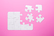 © lizaelesina - White puzzle on pink background. Top view